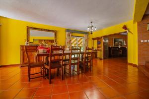 a dining room with yellow walls and a table and chairs at Quinta de São Francisco in Cinfães