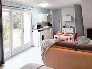 a living room with a couch and a kitchen with a table at Studio avec piscine partagee jardin clos et wifi a Saint Apollinaire in Saint-Apollinaire