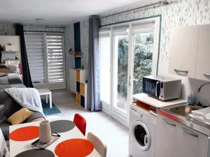 a kitchen and living room with a table and a microwave at Studio avec piscine partagee jardin clos et wifi a Saint Apollinaire in Saint-Apollinaire