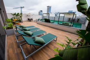 a rooftop deck with green chairs and a pool at EXCELENTE Studio V915 Vila Olímpia in Sao Paulo