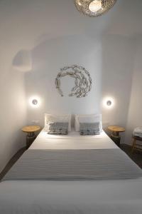 a bedroom with a large white bed with two tables at The Sunset Windmill in Oia