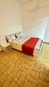 um quarto com uma cama com um cobertor vermelho em Studio Loulou, Tsoundzou2 em Mamoudzou