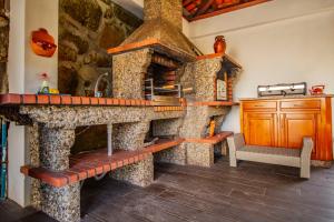 a kitchen with a large stone oven with a bench at Quinta de São Francisco in Cinfães