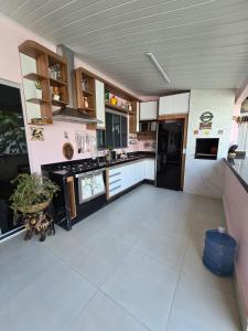 uma grande cozinha com electrodomésticos a preto e branco em Casa Rosa em Cuiabá