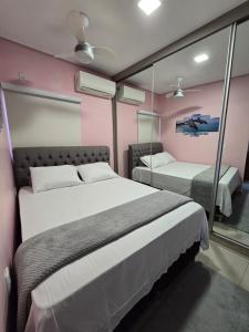 sypialnia z 2 łóżkami i lustrem w obiekcie Casa Rosa w mieście Cuiabá