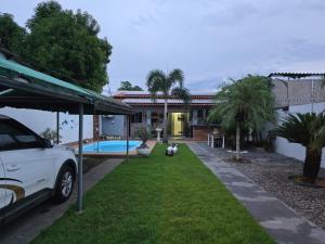 a white car parked in front of a house at Casa Rosa in Cuiabá