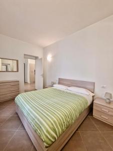 una camera da letto con un grande letto con una coperta verde e bianca di Al Centro del Centro Apartment by TraMonti a L'Aquila