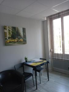 een kamer met een tafel en stoelen en een raam bij Studio du Parc thermal in Vittel