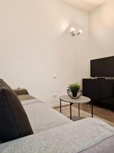 sala de estar con sofá y mesa en Al Centro del Centro Apartment by TraMonti, en LʼAquila
