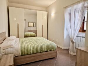 1 dormitorio con cama y ventana grande en Al Centro del Centro Apartment by TraMonti, en LʼAquila