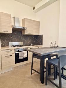 una cucina con tavolo, 2 sedie e piano cottura di Al Centro del Centro Apartment by TraMonti a L'Aquila Altre 19 foto