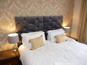 a bedroom with a large white bed with two lamps at Seven Stars - Bed & Breakfast & Restaurant in Okehampton