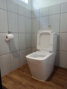 a white toilet in a bathroom with a roll of toilet paper at Edladleni Guesthouse Quigney in East London