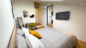Alfea Deluxe Loft & Rooms في ترينتو: غرفة نوم عليها سرير ومخدة صفراء