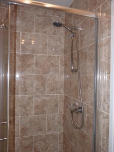 een badkamer met een douche en een glazen deur bij Seven Stars - Bed & Breakfast & Restaurant in Okehampton