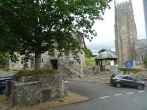 een auto geparkeerd voor een kerk met een toren bij Seven Stars - Bed & Breakfast & Restaurant in Okehampton