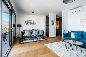 a living room with a blue couch and a table at Monte Living by In Property in Ðenaši