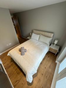 a bedroom with a bed with a stuffed animal on it at IVI Granton Harbour Apartment in Edinburgh