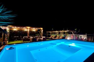 a swimming pool at night with lights on a deck at Pearl Seaside Cozy Apartments in Chania