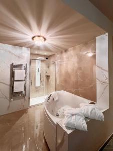 La salle de bains est pourvue d'une baignoire, d'une douche et de serviettes. dans l'établissement Hotel Motel Top, à Cusago