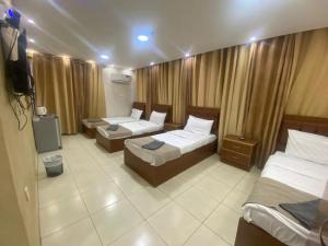Cette chambre comprend deux lits et une télévision. dans l'établissement Zuwwar Aqaba, à Aqaba