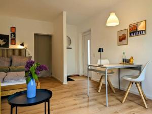 Apartment mit Balkon in Hannover-Ahlem في هانوفر: غرفة معيشة مع إناء من الزهور على طاولة