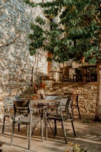 uma mesa e cadeiras em frente a uma parede de tijolos em Berat Backpackers Hostel em Berat