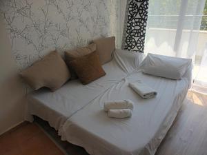 a white bed with two stuffed animals on it at Studio Marina Cape 89 in Aheloy