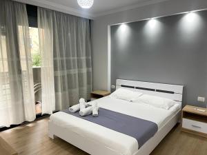 ein Schlafzimmer mit einem großen weißen Bett mit Handtüchern darauf in der Unterkunft New Bazaar 2022 in Tirana
