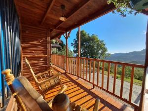 un porche de una cabaña con dos sillas en Cabaña Monarca – The BEST View in The Area!, en Jardín