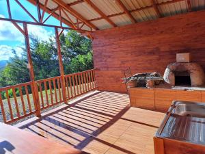 un gran porche de madera con horno al aire libre en Cabaña Monarca – The BEST View in The Area!, en Jardín