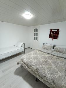a white bedroom with two beds in it at Eagle House in Bosteri