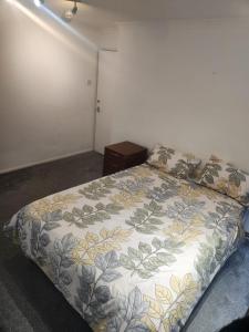 um quarto com uma cama com colcha floral em Sariyu space em Dagenham