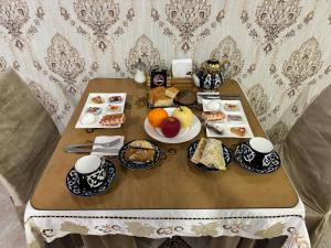 a table with plates of food on it at Qamar Hotel in Bukhara +55 photos