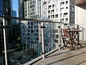 a chair on a balcony with a view of a building at Canary Wharf Serviced Apartments in London