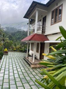 a house with a view of the mountains at NATURE FAMILY HOMESTAY in Munnar