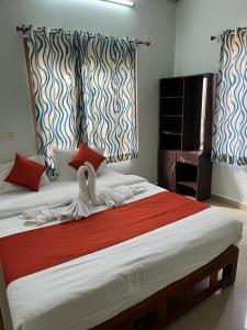 a bedroom with a large bed with swans on it at NATURE FAMILY HOMESTAY in Munnar