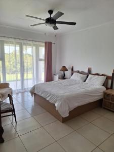a bedroom with a bed and a ceiling fan at Nature view in Tzaneen