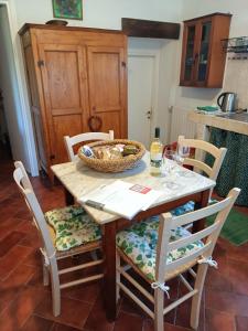 een tafel en stoelen met een mand met eten erop bij Il Mandorlino Pitigliano appartamento in tipico casale maremmano con portico e giardino in Pitigliano