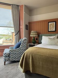 a bedroom with a bed and a chair and a window at Mill on the Exe in Exeter
