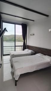 - 2 lits dans une chambre avec vue sur l'eau dans l'établissement Casa Natura Prado, à Boquerón de Tena