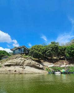 Boquerón de Tena的住宿－Casa Natura Prado，水体旁山顶上的房子