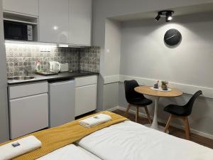 una pequeña cocina con una cama y una mesa en ILLA Apartments en Eger