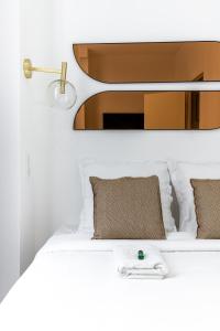 a bedroom with a white bed with a mirror at HSH St Germain/Jardin du Luxembourg : Luxury Apartment in Paris