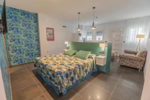 a bedroom with a bed and a couch and a chair at Hotel Adiafa in Barbate