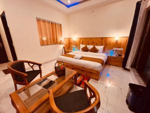 a hotel room with a bed and a table and chairs at Sumitra Guest House in Amritsar