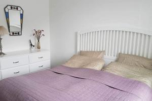 una camera da letto con un letto con una coperta viola e un comò di Feriehus i Sæby nær by, skov og strand a Sæby