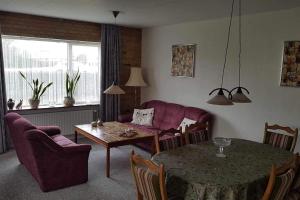 een woonkamer met een paarse bank en een tafel bij Feriehus i Sæby nær by, skov og strand in Sæby