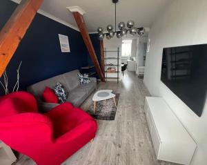 a living room with a red couch and a red chair at Attic close to the beach and city center in Kołobrzeg