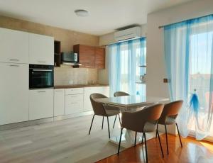 a kitchen with a table and chairs in a room at Skajla Apartments in Medulin